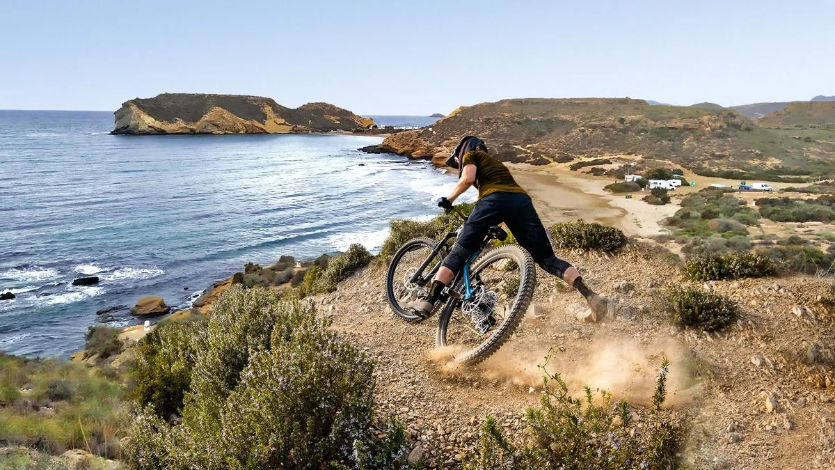 Mountain biker descending a coastal trail on the Cartagena shoreline